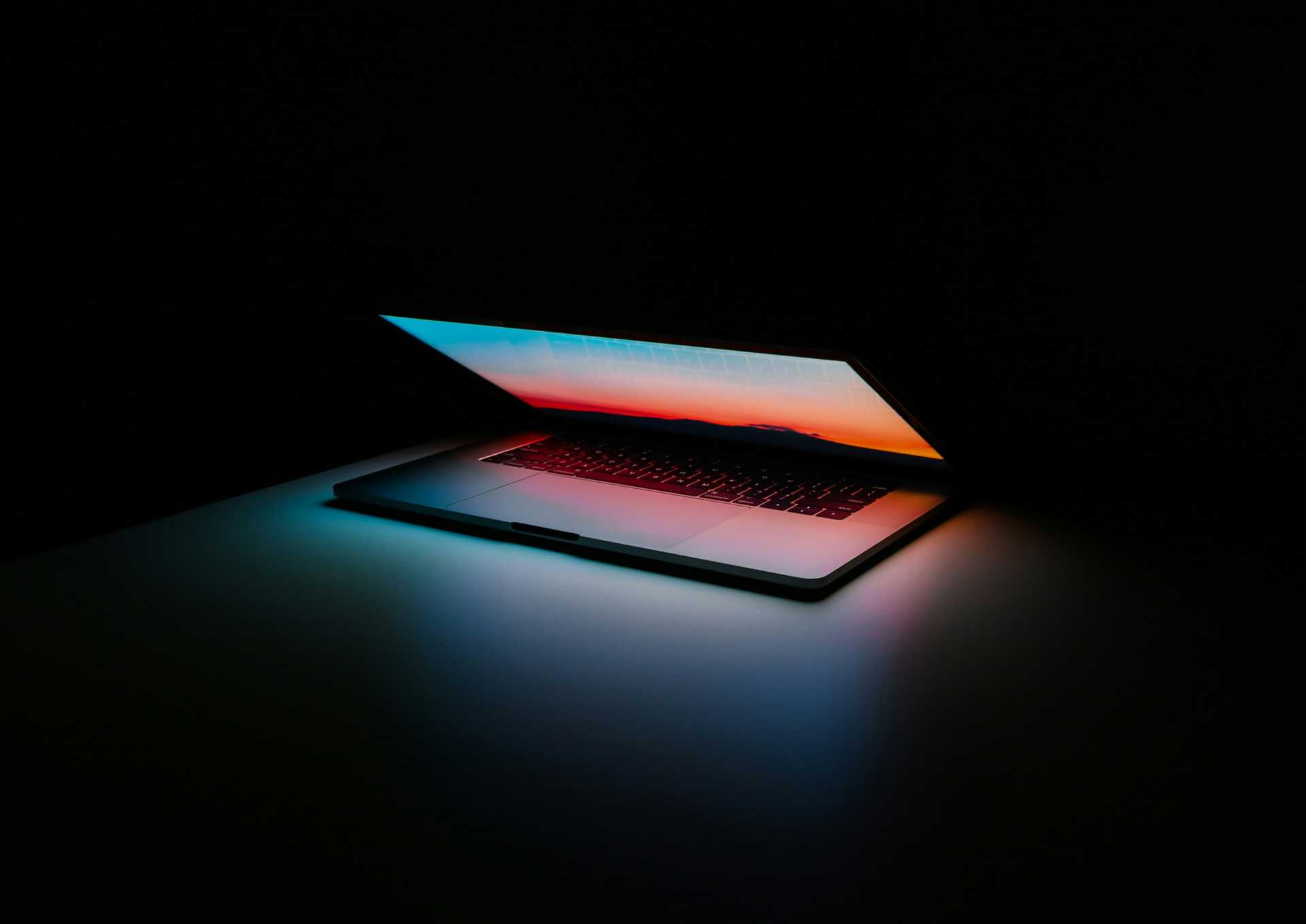 A laptop partially opened on a dark background